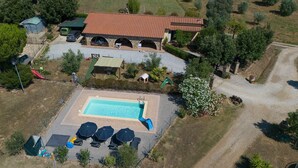 Ein Wohnhaus mit Schwimmbad, Sitzgelegenheiten im Freien und einem Garten.