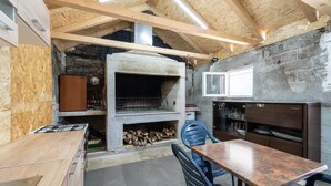 Une cuisine rustique avec un poêle à bois, une table à manger et des chaises.