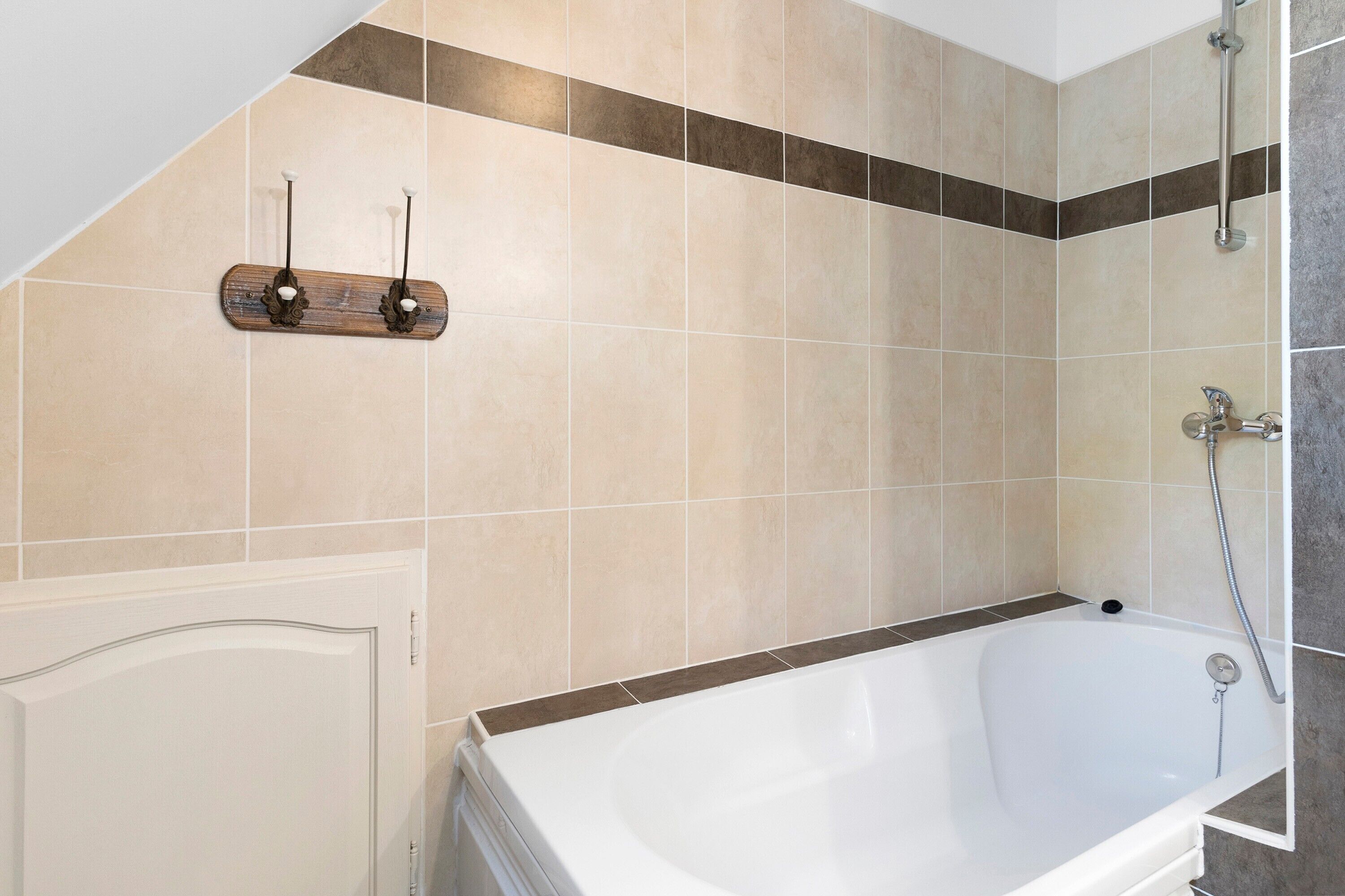 Un bagno con una vasca, una doccia e un portasciugamani.