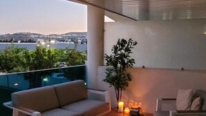 A modern outdoor seating area with a sofa, chairs, and a table, featuring a view of a cityscape. - Apartment 'Jardines De Las Lagunas' with Mountain View, Wi-Fi and Air Conditioning (Las Lagunas de Mijas)
