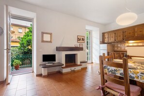 A kitchen with wooden cabinets, a dining table, and a television.