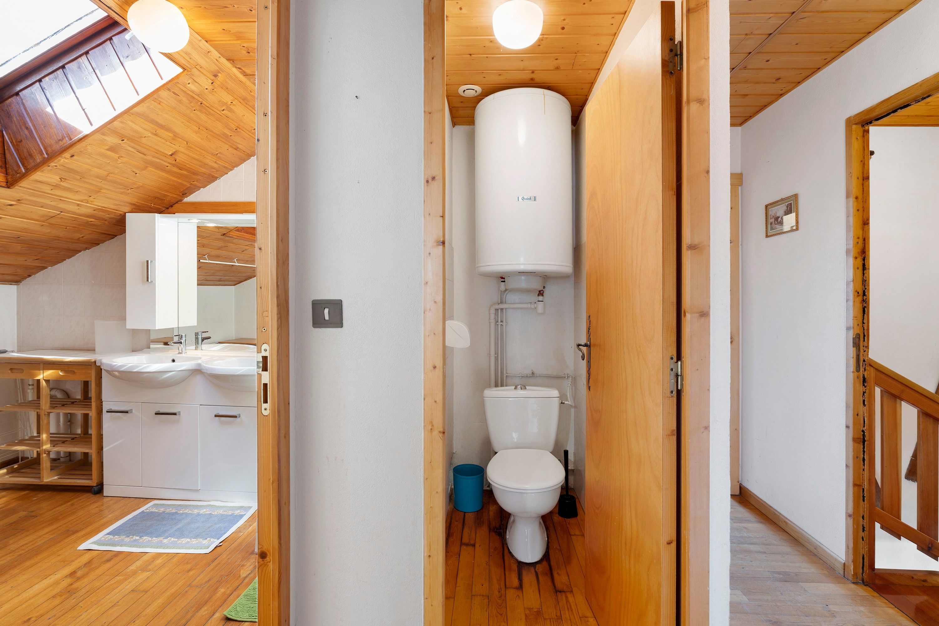 A wooden interior with a white toilet, a sink, and a mirror in a small bathroom.