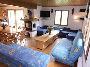 En hyggelig stue med en sofa, et træbord og et fjernsyn.