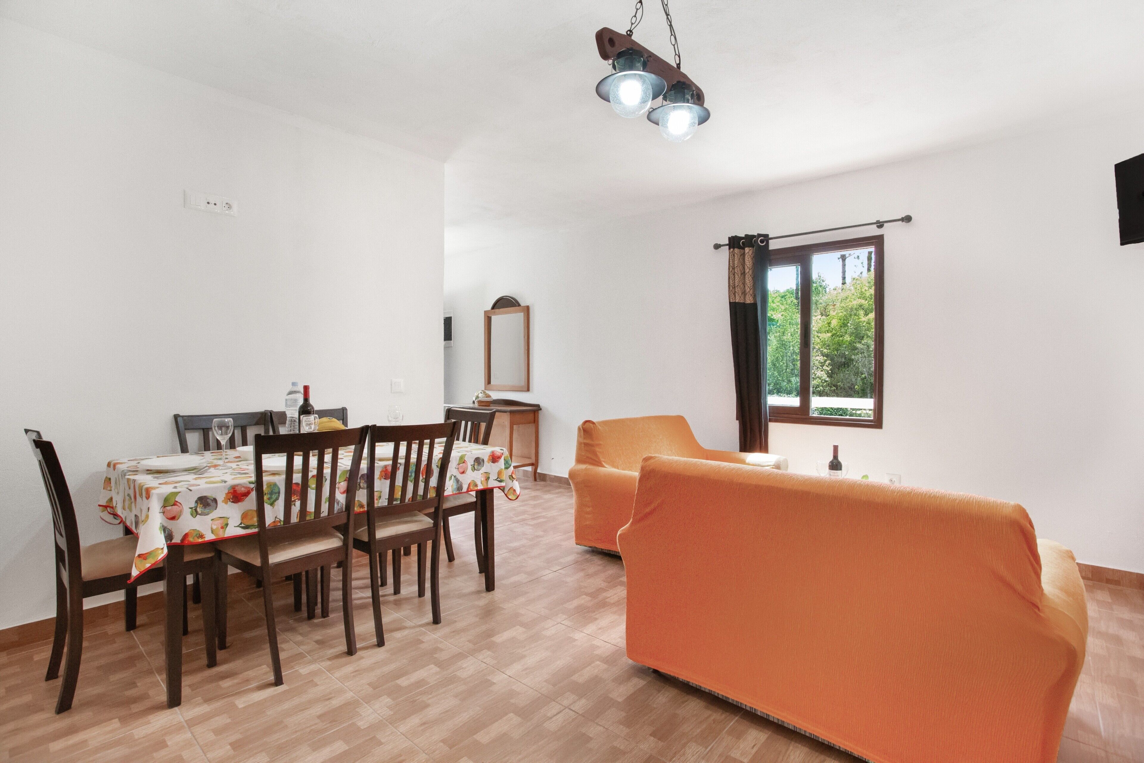 A dining area with a table, chairs, and a sofa.
