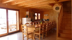 Ein Holzblockhaus mit Essbereich, Küche und einer Treppe.