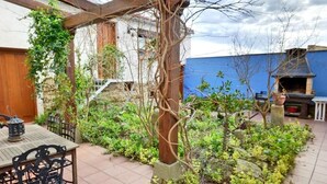 A patio with a table and chairs, a pergola, and a barbecue area. - La Tahona: Sustainable Country House for Cyclists, Starlight-Certified in Lerín (Lerín)