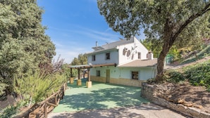 Een huis met een groen dak, een overdekte patio en een stenen muur.