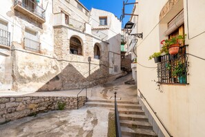 A narrow street with stone buildings, a staircase, and a railing. - Rural House 'Ca La Germandat Paüls' with Mountain Views, Private Terrace and Wi-Fi (Pauls)
