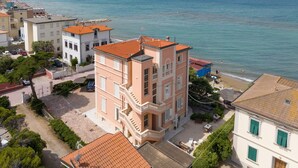 A coastal building with multiple balconies, a beach in the background, and a clear sky. - Apartment 'Villa Corallo - Acqua Marina' with Sea View, Wi-Fi and Air Conditioning (San Vincenzo)