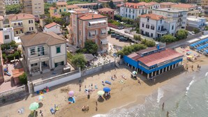 An aerial view of a coastal town with buildings, a beach, and a blue building with columns. - Apartment 'Villa Corallo - Acqua Marina' with Sea View, Wi-Fi and Air Conditioning (San Vincenzo)