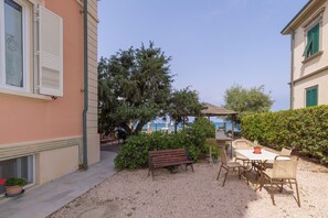 A patio with a table and chairs, a bench, and a potted plant. - Apartment 'Villa Corallo - Corniola' with Sea View, Wi-Fi and Air Conditioning (San Vincenzo)