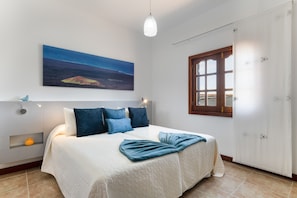 Una camera da letto con un letto, un quadro, una finestra e una porta.