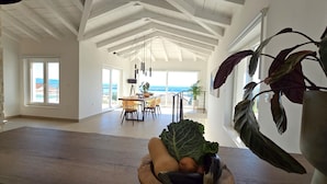 Una cocina espaciosa con una isla grande, un comedor con vistas y un balcón con vista al mar.