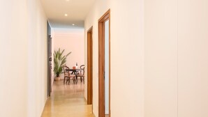 A hallway with a dining area at the end, featuring a table and chairs, and a potted plant. - 605A Residenza Gigli (Garda)