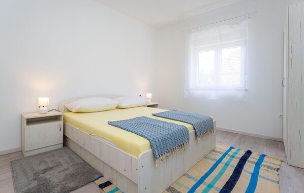 A bedroom with a bed, bedside tables, a window, and a door. - Beautiful home in Sukosan (Sukosan)