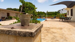 A patio area with a concrete planter, a pool, and outdoor furniture. - Beautiful home in Sukosan (Sukosan)