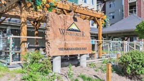 Ein Holzschild mit der Aufschrift 'Windtower 160 Kananaskis Way' und einem Berglogo.
