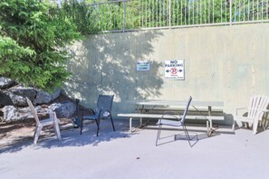 A designated parking area with a no parking sign, a picnic table, and chairs. - Spacious High-End Air Conditioned, 2 Bedroom 2 Bathroom Condo In Canmore/Banff. (Canmore)