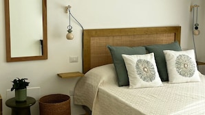 A bedroom with a wooden headboard, a large mirror, and two bedside tables with wall-mounted lamps. - Appartamento in villa, 2 camere da letto e cucina (Bari)