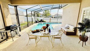 A covered patio with a pool, a grill, and outdoor furniture. - 15 Mint to Disney 2 mint to the Best golf courses. Family size villa.      (Davenport)