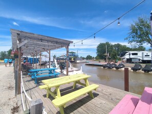 Une jetée équipée de tables de pique-nique, d’un espace de repos abrité et d’un bateau amarré à proximité.