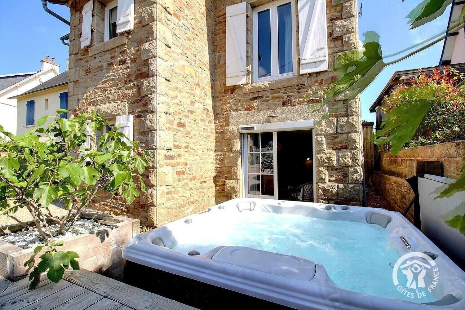 Ein Steinhaus mit Whirlpool im Garten.