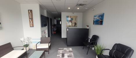 A hotel lobby with a reception desk, seating area, and artwork on the walls.