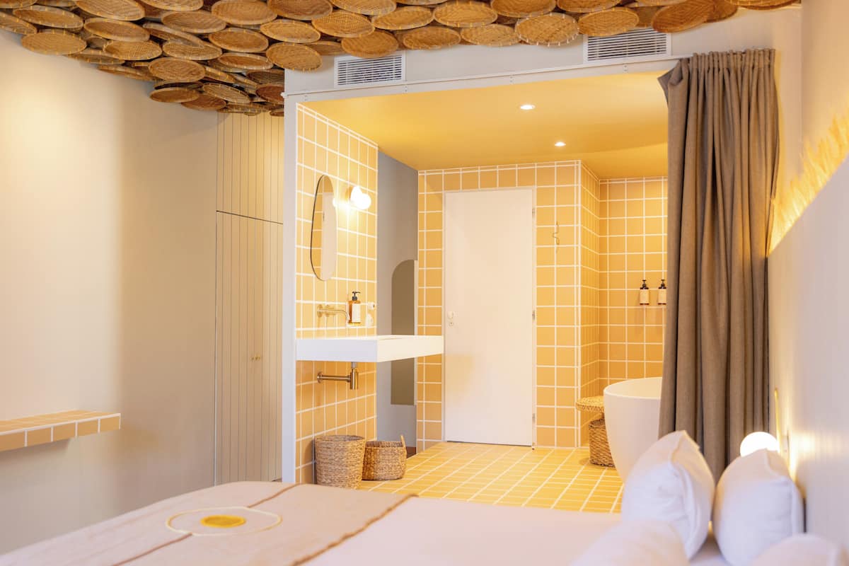 A modern bathroom with a white sink, a large mirror, and a bathtub.