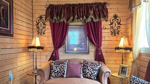 A cozy room with wooden walls, a sofa, two armchairs, a small table, and decorative lamps. - Paradise 2.0 at North River  (Beaufort)