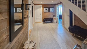Een houten interieur met een trap, een bank en een vloerkleed.