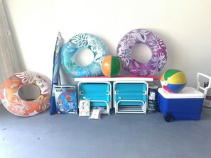 A variety of pool floats and a cooler on a table. - SAUNA! HUGE HOT TUB HEATED POOL UPDATED HOME 3 mileto beach 3BD 2BA 3 KING BEDS! (Seminole)