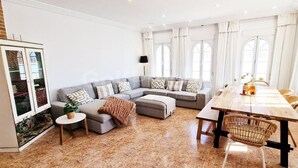 A spacious living room with a large sectional sofa, a dining table, and a cabinet. - Beautiful and Peacefull 3 Bed Villa with Private Pool, AC (Avileses)