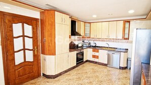 A kitchen with wooden cabinets, a stove, a sink, and a refrigerator. - Beautiful and Peacefull 3 Bed Villa with Private Pool, AC (Avileses)