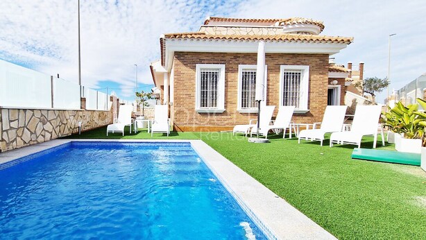 A swimming pool with a stone wall and a grassy area with lounge chairs. - Beautiful and Peacefull 3 Bed Villa with Private Pool, AC (Avileses)
