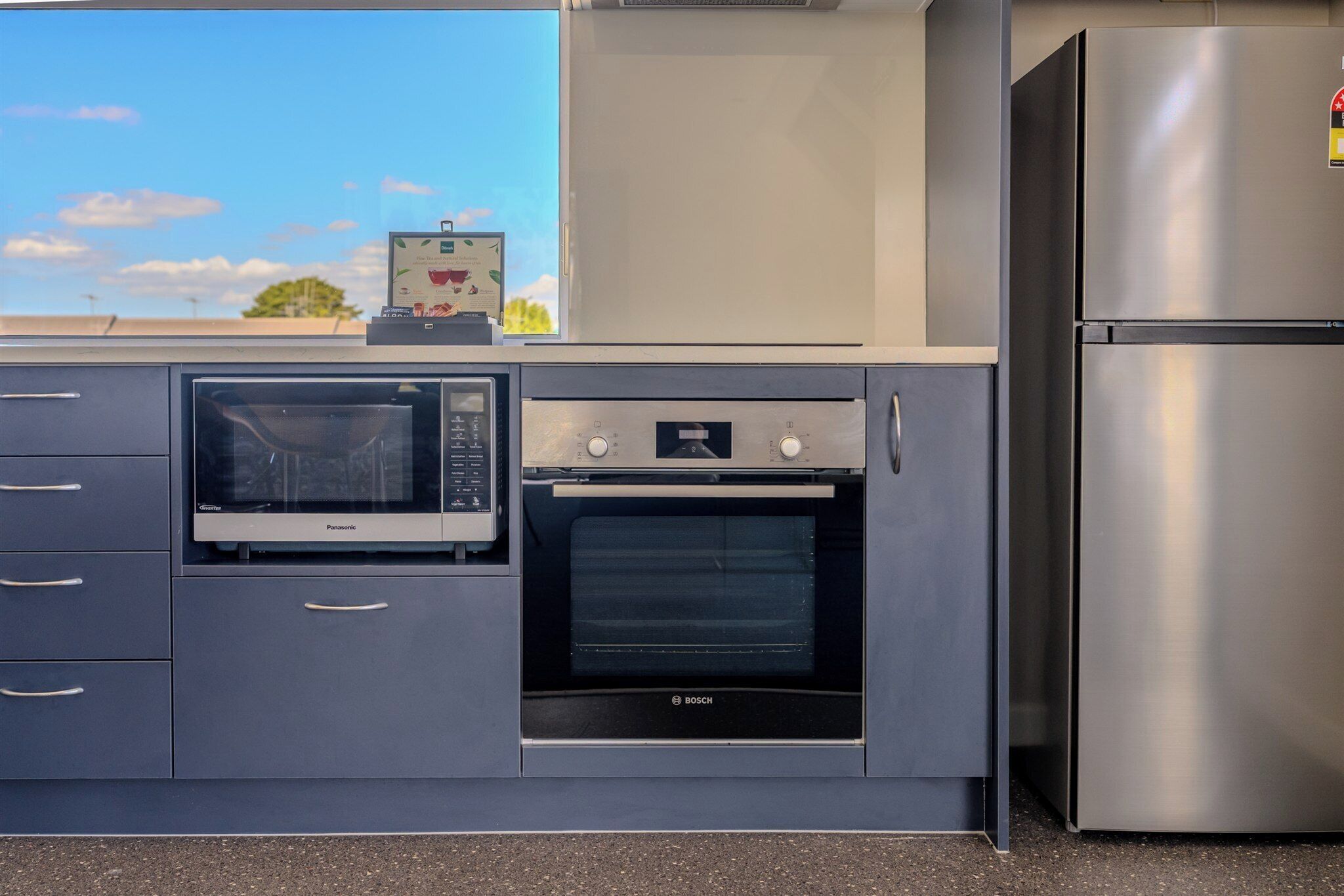 A compact kitchen with a microwave, oven, and refrigerator.