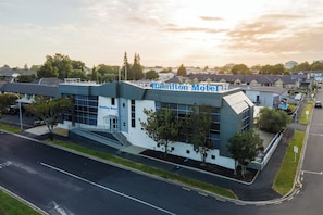 A modern motel with a flat roof, large windows, and a sign reading "Hamilton Motel." - Hamilton Motel 2025 Limited (Hamilton)