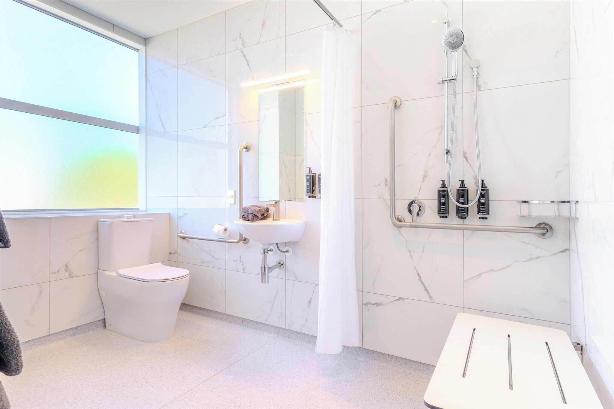 Un bagno moderno con WC, lavandino e doccia.