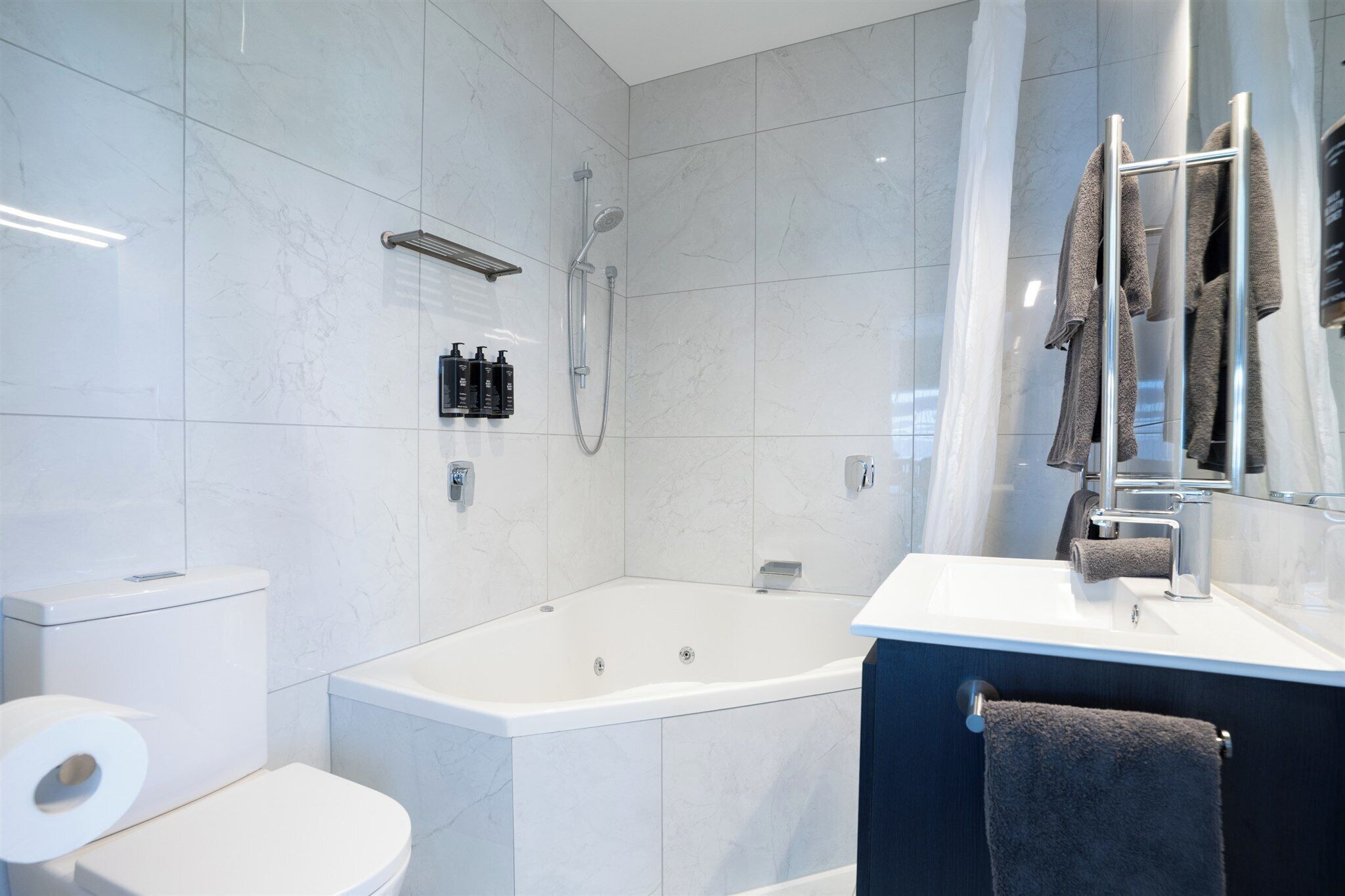 Ein modernes Badezimmer mit Badewanne, Toilette und Waschbecken.
