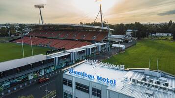 A stadium with a large seating area and a building labeled "Hamilton Motel" adjacent to it.