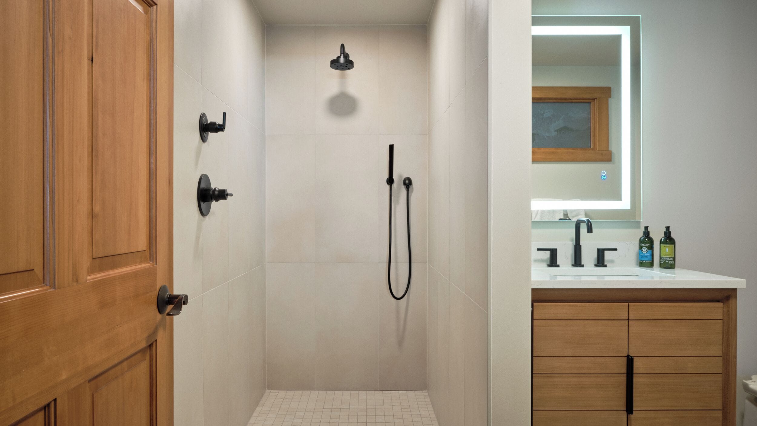 A bathroom with a shower, a sink, and a mirror.