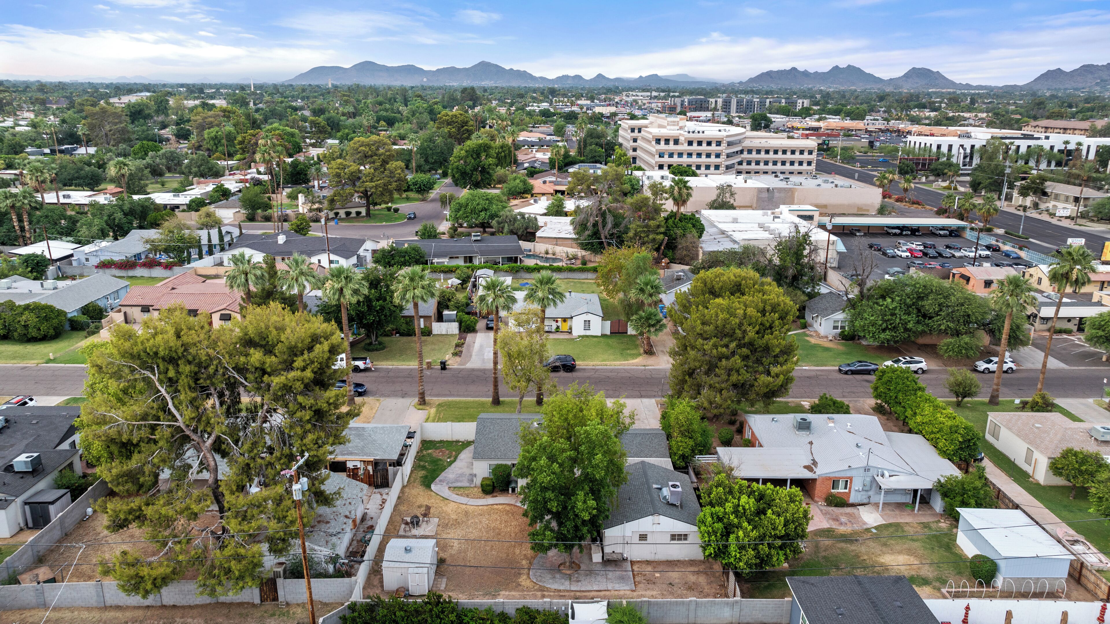 A residential area with houses, streets, and a large building in the background.