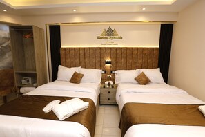 A hotel room with two beds, a wardrobe, a vanity, and a sign above the beds.