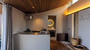 Una cocina moderna con una isla central, horno empotrado y una lámpara colgante.