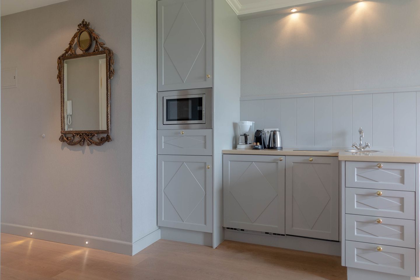A modern kitchen with built-in appliances, a microwave, and a coffee maker.