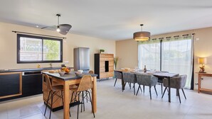 A modern kitchen with a dining area, large windows, and a view of the outdoors. - Les sablons by Interhome (Agon-Coutainville)