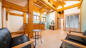 A cozy interior with wooden beams, a kitchen area, and seating arrangements. - Gyeongju Ipsaedalseumeunal (Gyeongju)