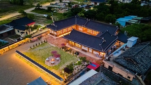 Vue aĂ©rienne dâun bĂątiment traditionnel dotĂ© dâune cour intĂ©rieure, entourĂ© dâautres constructions.