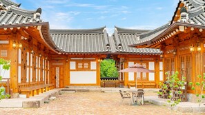 A traditional wooden building with a tiled roof and a courtyard with a table and chairs. - Gyeongju Ipsaedalseumeunal (Gyeongju)