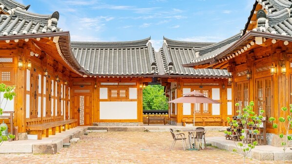 A traditional wooden building with a tiled roof and a courtyard with a table and chairs. - Gyeongju Ipsaedalseumeunal (Gyeongju)