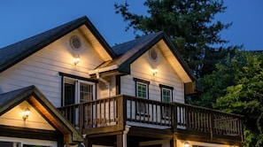 Une maison à deux étages dotée d’un balcon et d’un éclairage extérieur.